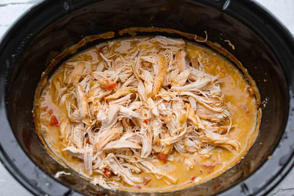 This crockpot chicken spaghetti will have everyone running to the dinner table! The slow cooker does the work while the chicken becomes tender and flavorful, then it's tossed with spaghetti, melty cheese, and a creamy sauce. Cooked chicken shredded in the sauce.