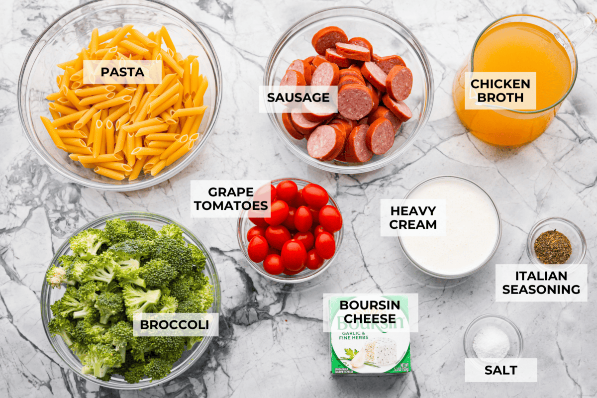Overhead shot of labeled creamy sausage pasta ingredients. 