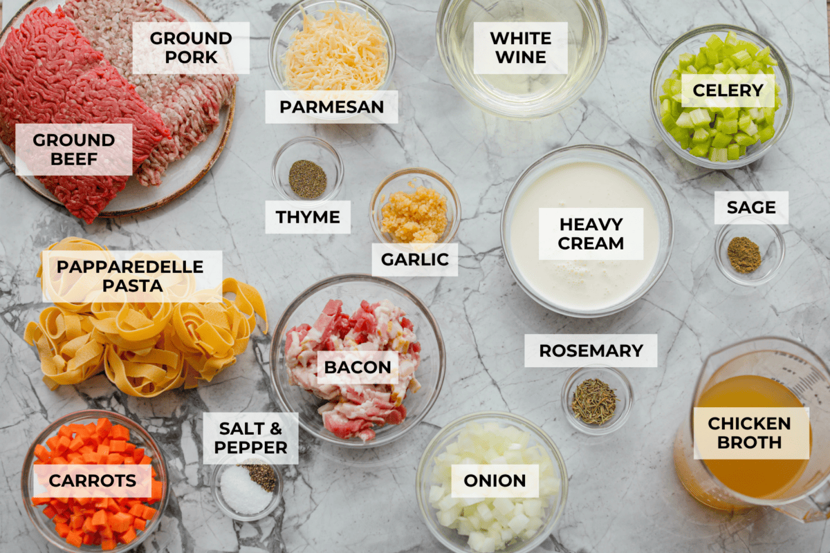 No tomatoes, no red sauce, just a rich, savory white bolognese loaded with beef, pork, bacon, white wine, and plenty of Parmesan. Tossed with noodles, it’s a fun and seriously delicious twist on classic Bolognese. Overhead shot of labeled white bolognese ingredients.