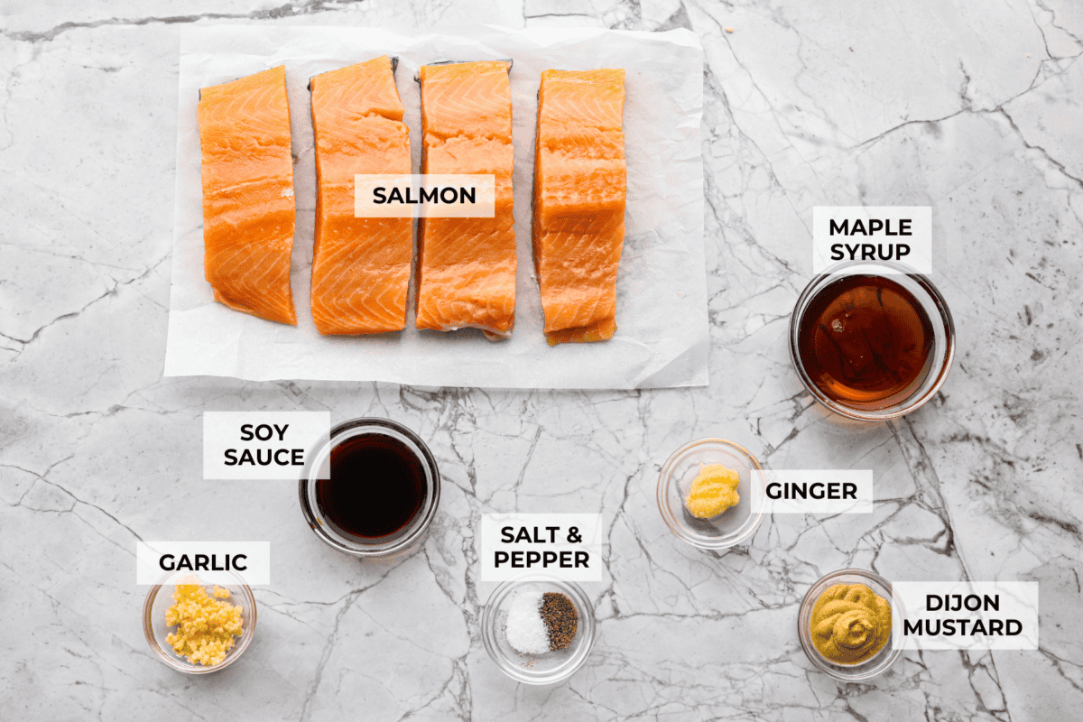 Maple glazed salmon has that perfect sweet-and-savory flavor that keeps you going back for just one more bite. As it bakes, the maple glaze turns glossy and caramelized while the salmon stays buttery, flaky, and melt-in-your-mouth tender. Overhead shot of labeled ingredients.