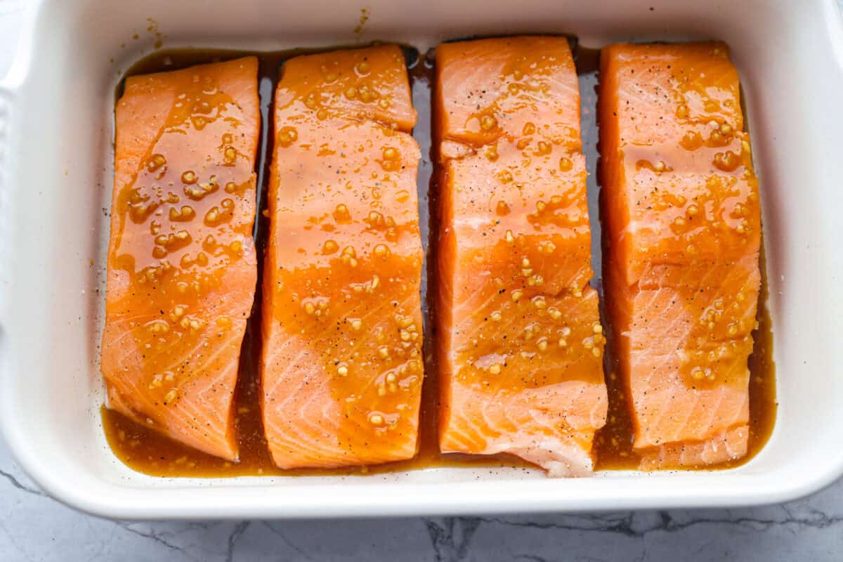 Maple glazed salmon has that perfect sweet-and-savory flavor that keeps you going back for just one more bite. As it bakes, the maple glaze turns glossy and caramelized while the salmon stays buttery, flaky, and melt-in-your-mouth tender. Sauce poured over the salmon ready to be cooked.