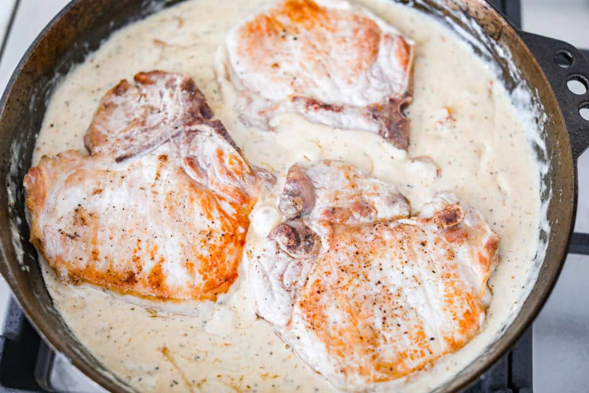 Seared pork chops added back into the sauce to simmer and finish cooking. 