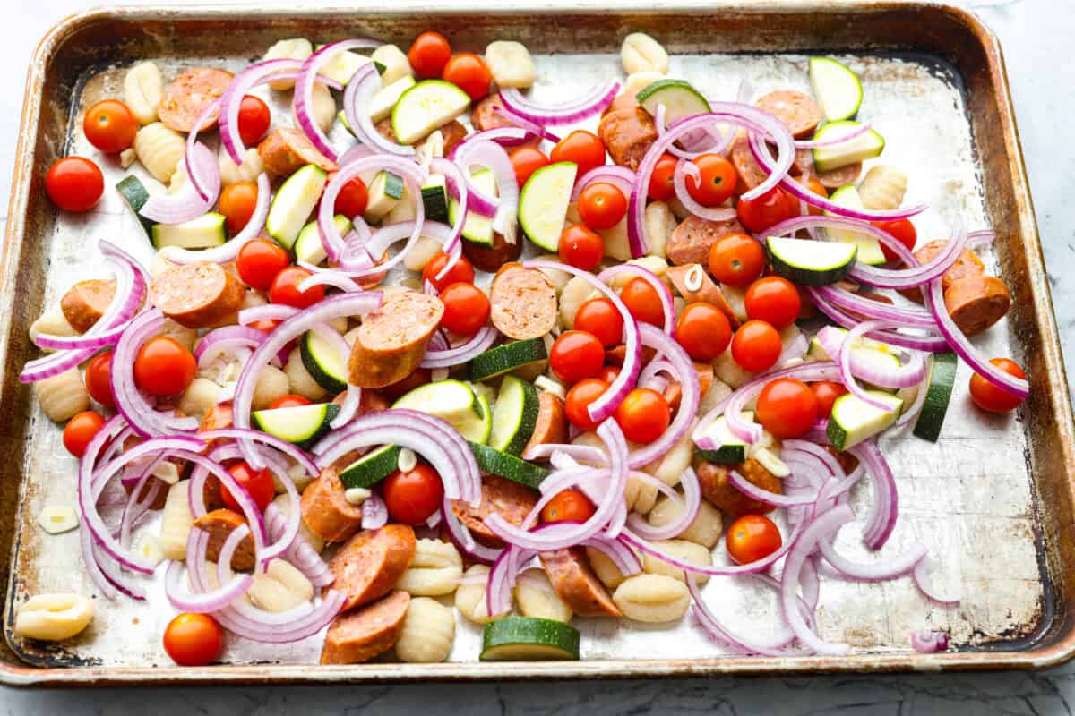 This sheet pan gnocchi is about as easy as dinner gets! Everything goes onto one pan with olive oil and Italian seasoning, then roasts until the gnocchi is crispy and the veggies are tender. Finish it with Parmesan and dig in! Veggies, gnocchi, and sausage spread out on a sheet pan.