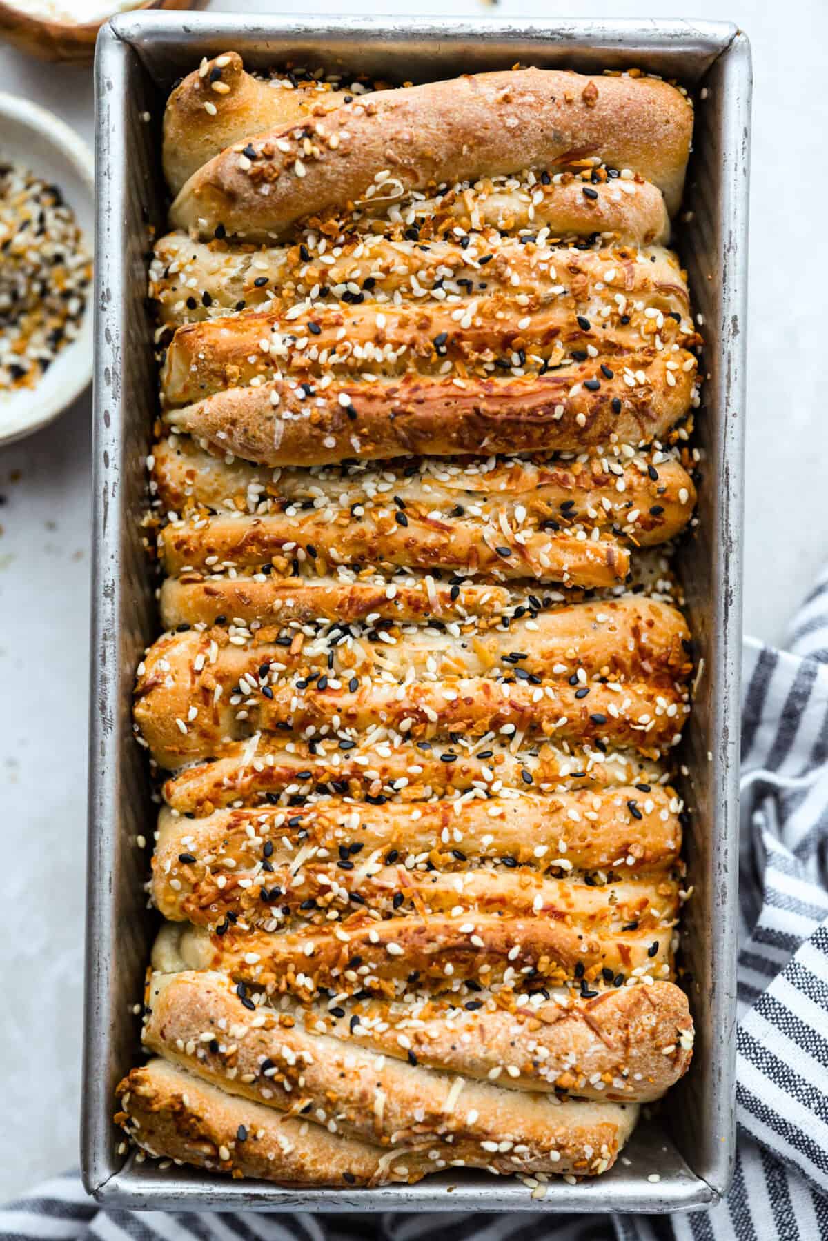 Everything bagel pull apart bread is soft, cheesy, and loaded with savory flavor in every layer. The homemade dough is stacked with Parmesan cheese and everything bagel seasoning, then baked until golden and fluffy. Everything bagel seasoning pull apart bread all baked and golden brown.