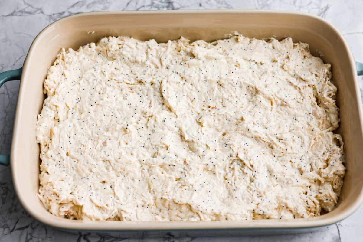 Poppy seed chicken casserole is creamy, cozy, and so easy to make! Tender chicken is topped with buttery Ritz crackers for the perfect crunch, and it’s ready in just 35 minutes. Ingredient mixture spread out in the bottom of the2 quart baking dish.