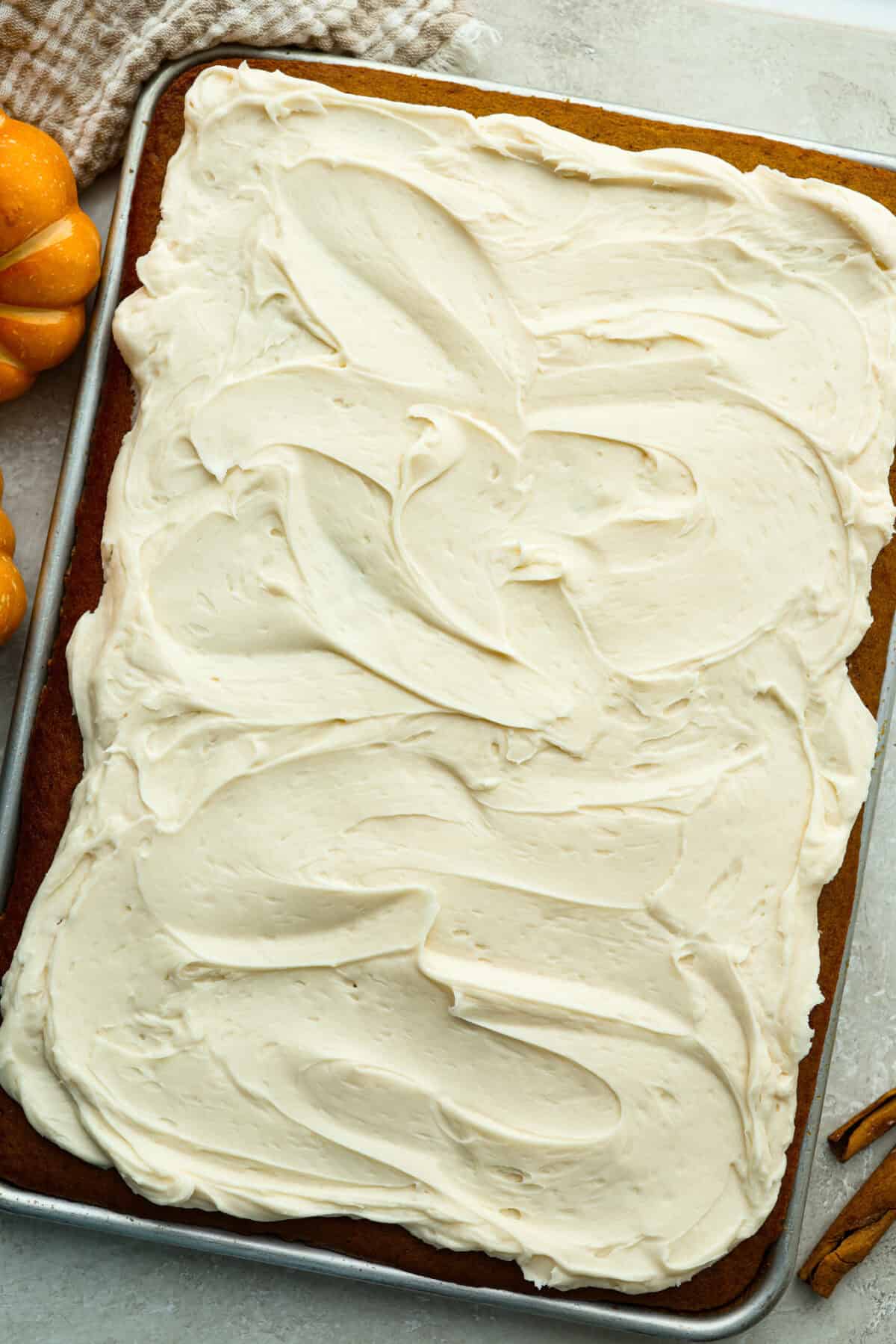 Overhead shot of pumpkin sheet cake bars slathered in cream cheese frosting. 