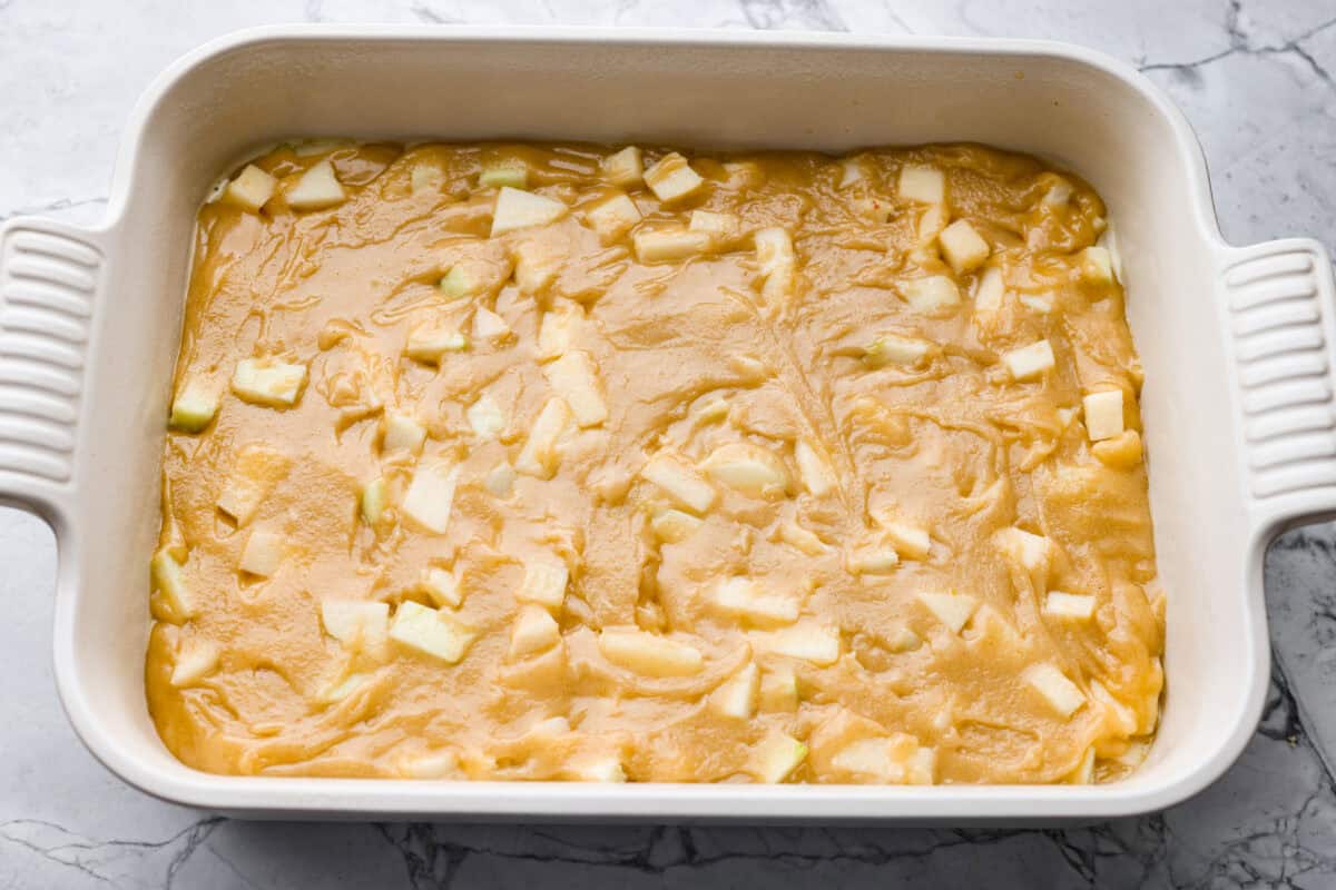 If you love cozy apple desserts, this apple dapple cake is going to be your new fall favorite. It’s packed with fresh apples and warm cinnamon, topped with a buttery caramel glaze that sinks right into the cake. Batter spread out in the bottom of the baking dish.