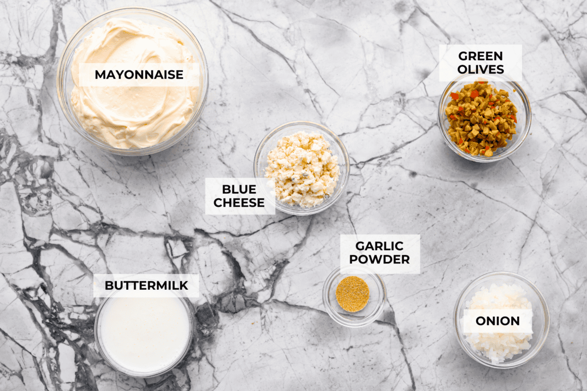 Say hello to Oklahoma dip, the viral party dip with serious dirty martini vibes! Creamy mayo, salty green olives, blue cheese, and buttermilk come together. This bold, briny dip that’s perfect for dunking, spreading, and scooping. Overhead shot of labeled Oklahoma dip ingredients.