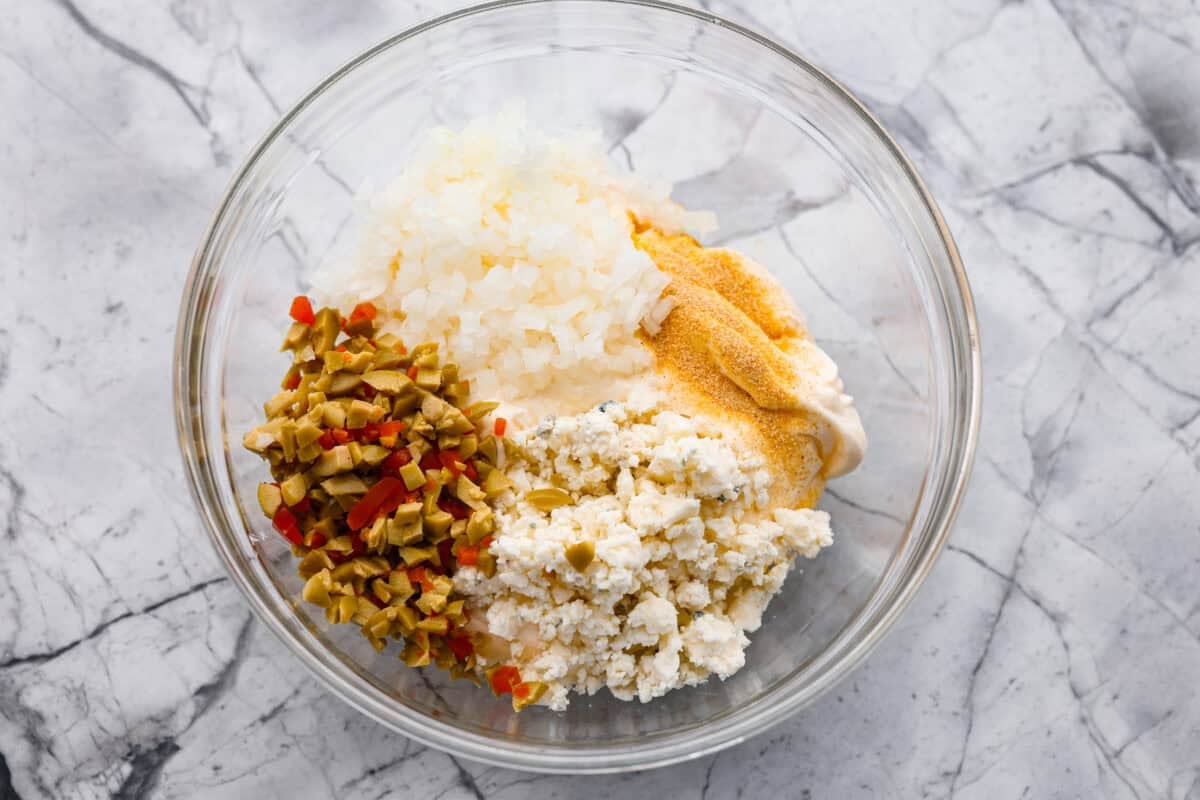 Say hello to Oklahoma dip, the viral party dip with serious dirty martini vibes! Creamy mayo, salty green olives, blue cheese, and buttermilk come together. This bold, briny dip that’s perfect for dunking, spreading, and scooping. All of the ingredients added to a bowl.