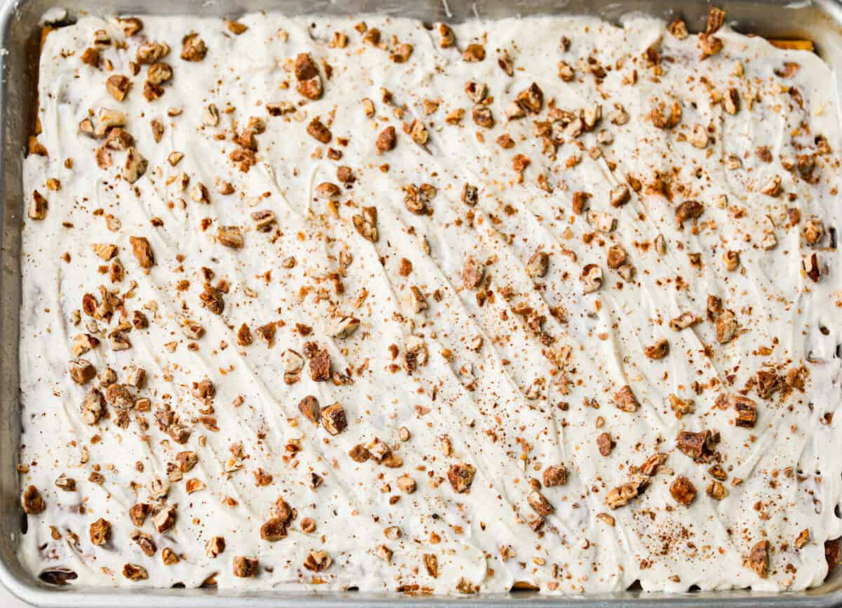 Pumpkin spice crack is Christmas crack with a fall twist! Buttery toffee, salty crackers, white chocolate, pumpkin pie spice, and crunchy praline pecans make this an easy treat you won’t be able to stop snacking on. Pecans and pumpkin pie spice sprinkled over the top of the crack.