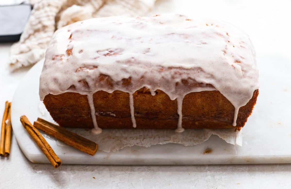 This snickerdoodle donut loaf is a fun twist on the classic cookie! It’s soft, tender, and packed with cinnamon sugar flavor, then finished with a sweet vanilla glaze. Think snickerdoodle meets cake donut in an easy-to-slice loaf! Glaze poured over the top of the snickerdoodle donut loaf.