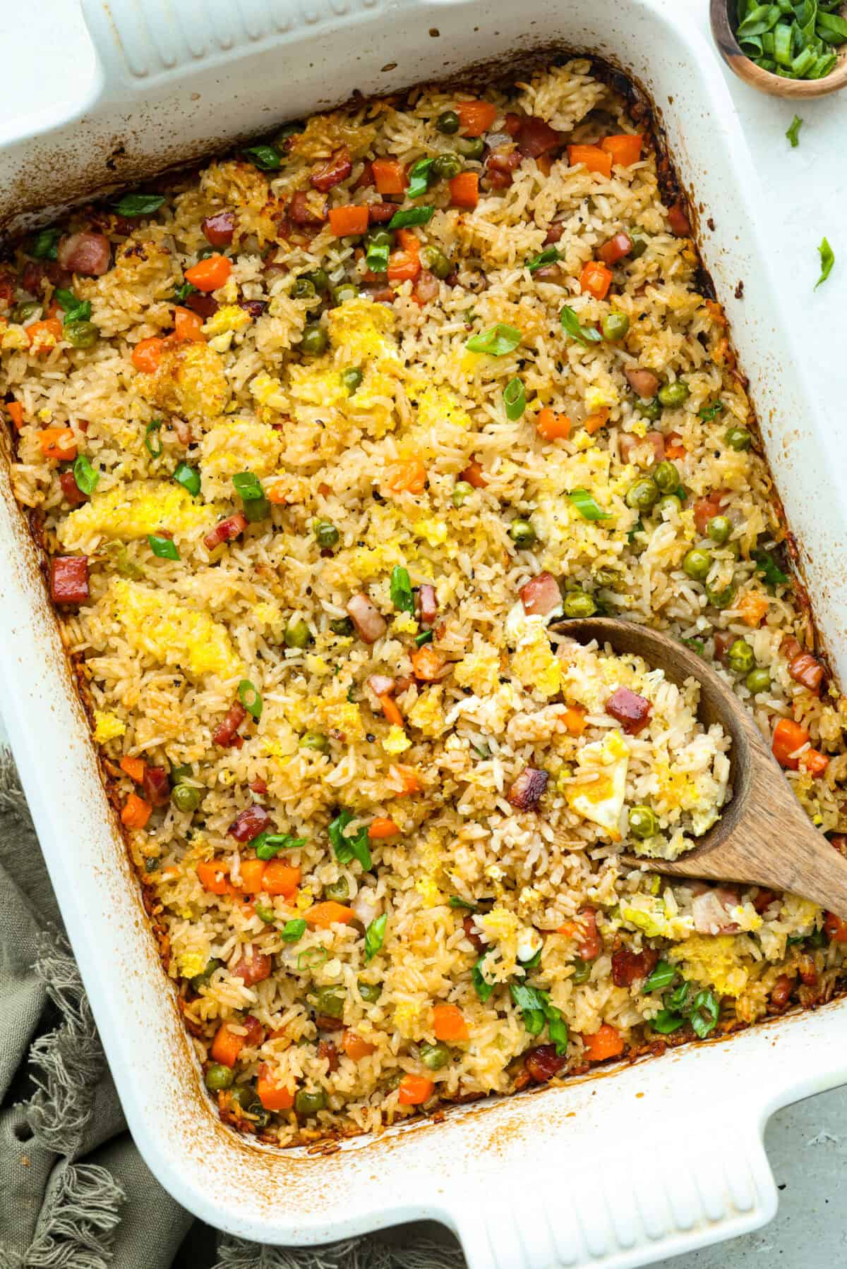 I LOVE fried rice, and my classic fried rice is already so easy, but I’m obsessed with this baked version! Dump everything into one baking dish, pop it in the oven, and dinner is served. It has all that savory fried rice flavor with less work! Top down shot of baked fried rice out of the oven!