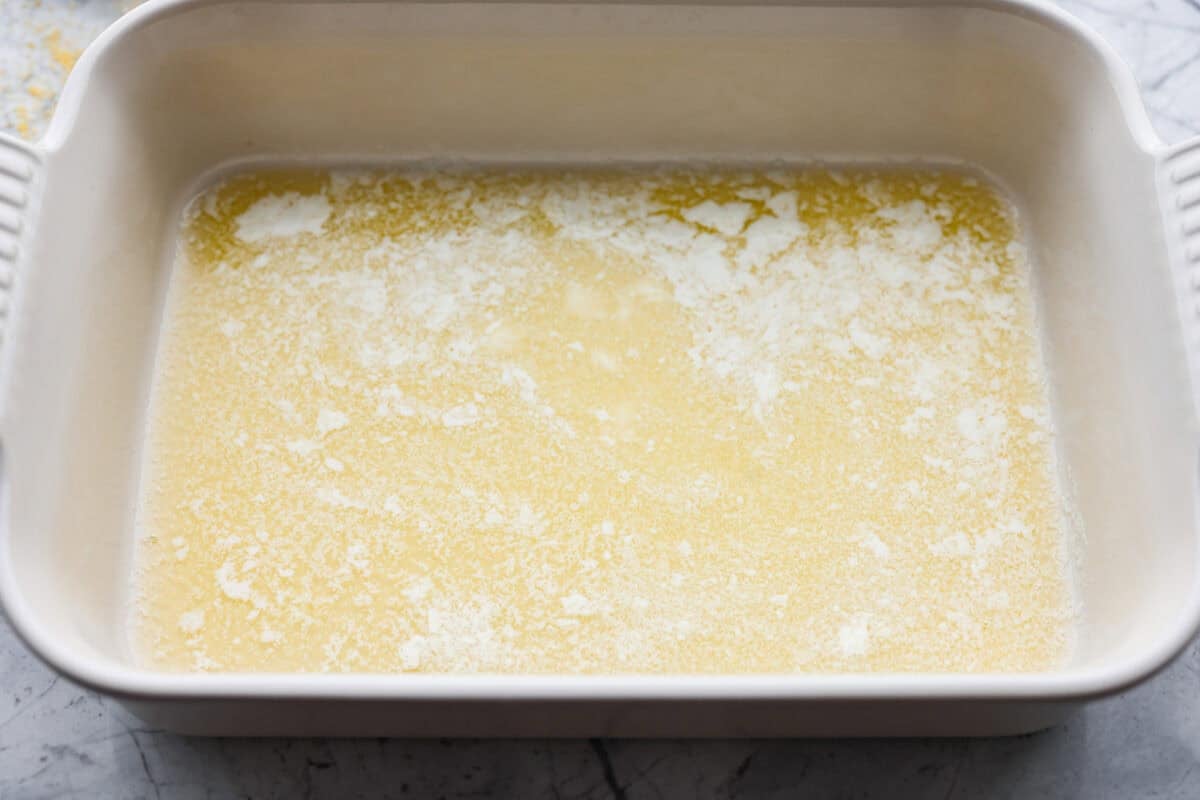 Butter swim cornbread bakes in a whole stick of butter, giving it crisp, golden edges and a soft, tender center. My secret ingredient is a can of creamed corn, which makes it extra moist and adds even more sweet corn flavor. Melted butter in the bottom of the baking dish.