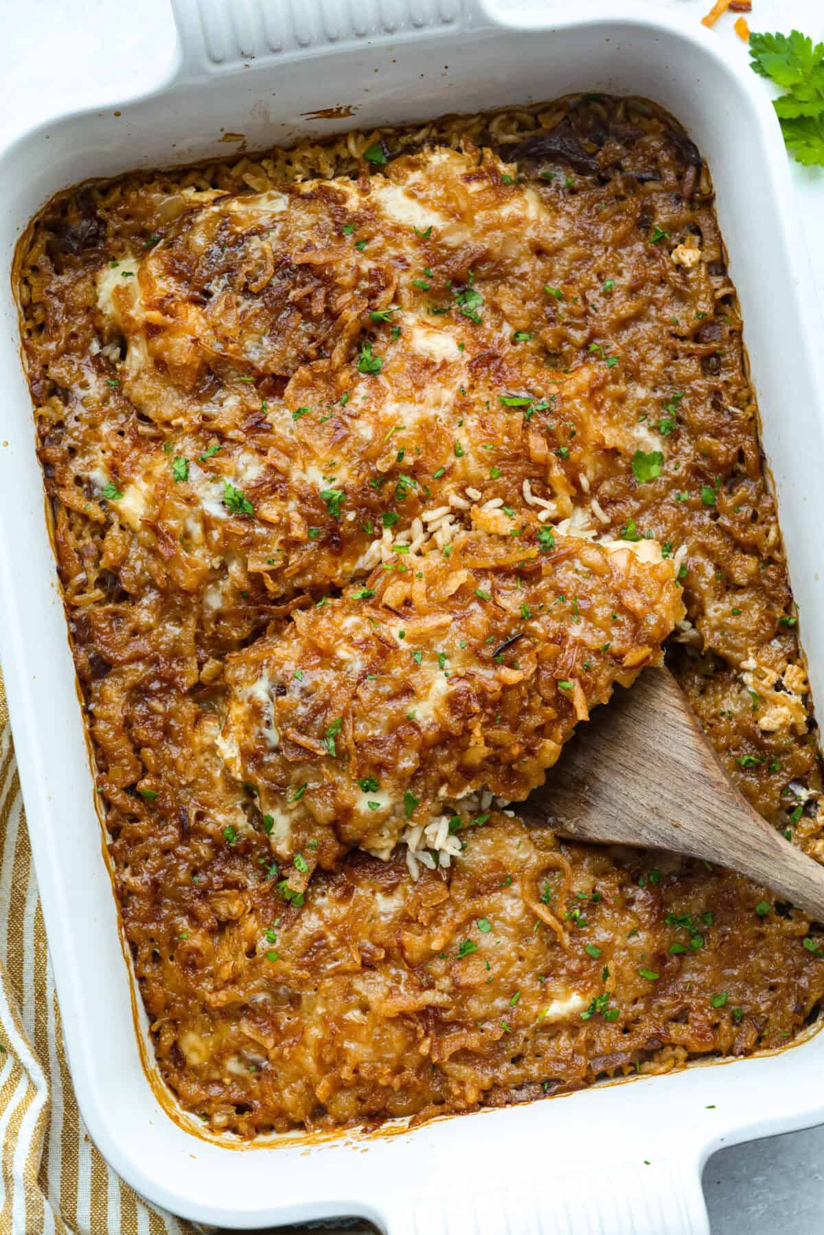 French onion chicken and rice casserole brings the rich, savory flavor of French onion soup to an easy, cheesy dinner. Tender chicken, fluffy rice, melty provolone, and crispy fried onions all come together in one pan with just 10 minutes of prep. Top down shot of french onion chicken and rice casserole baked and ready to eat.