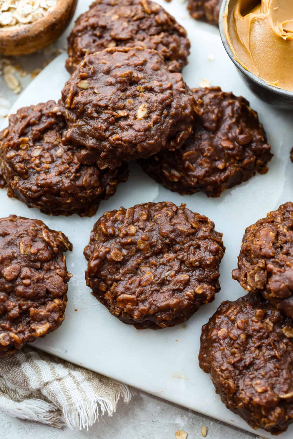 These classic no bake cookies are loaded with chocolate, creamy peanut butter, and chewy oats. They come together in just minutes on the stovetop, and you don’t even have to turn on the oven! No bake cookies set and spread out on a cookies sheet.