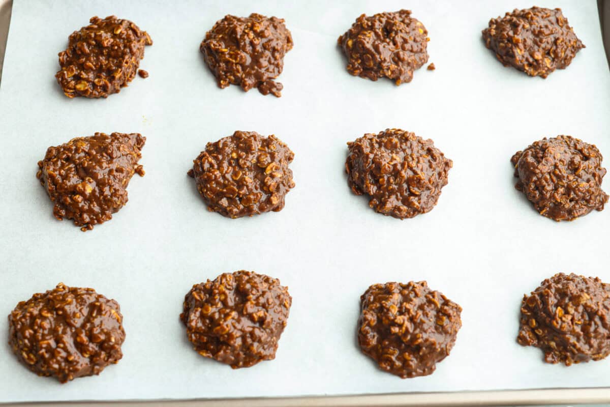 These classic no bake cookies are loaded with chocolate, creamy peanut butter, and chewy oats. They come together in just minutes on the stovetop, and you don’t even have to turn on the oven! Scoops of cookie dough placed on a cookie sheet.