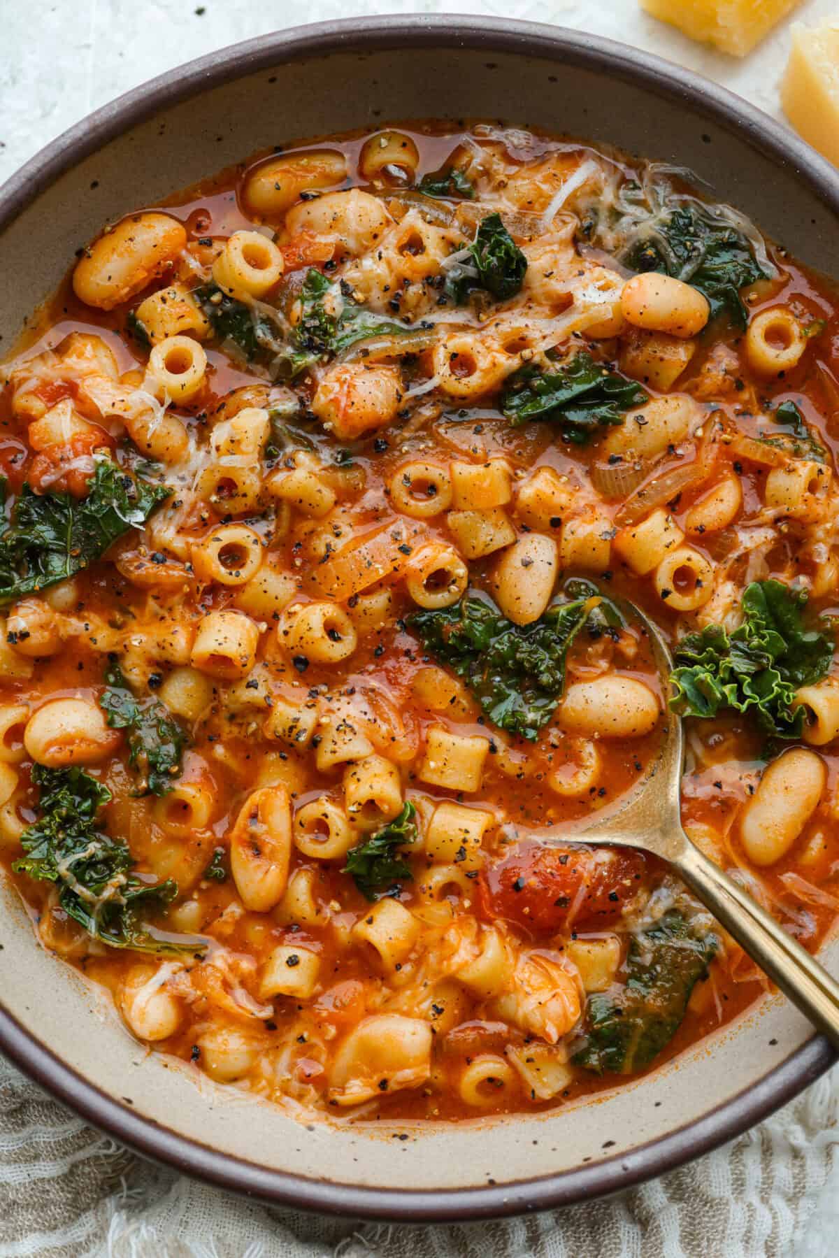 I had to try Stanley Tucci’s pasta fagioli, and his shortcut is so smart! He uses marinara sauce to add tons of flavor without a long list of ingredients. Add creamy beans, tender pasta, kale, and Parmesan, and you have a cozy dinner in just 35 minutes. Serving bowl of Stanley Tucci Pasta Fagioli topped with parmesan cheese.