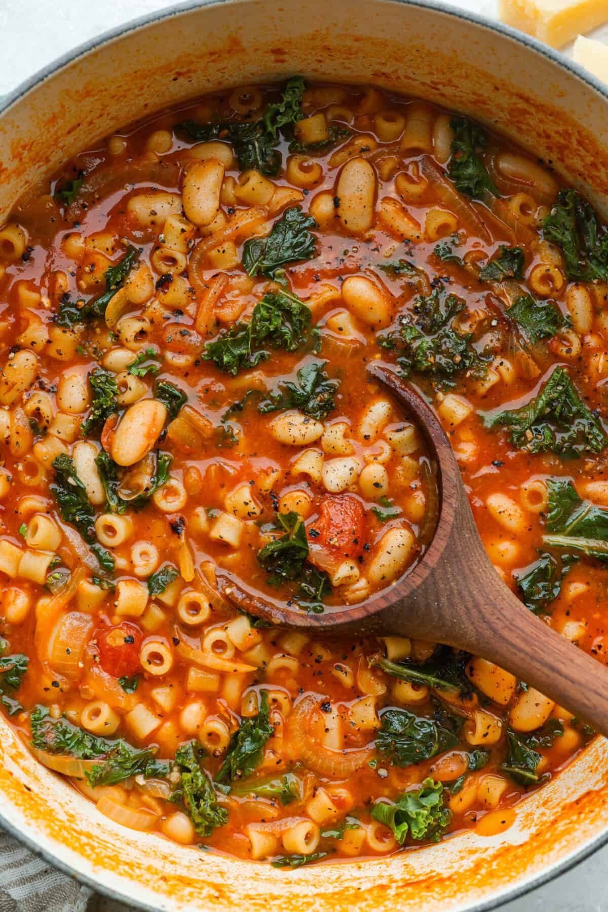 I had to try Stanley Tucci’s pasta fagioli, and his shortcut is so smart! He uses marinara sauce to add tons of flavor without a long list of ingredients. Add creamy beans, tender pasta, kale, and Parmesan, and you have a cozy dinner in just 35 minutes. Large dutch oven with cooked Stanley Tucci pasta fagioli soup and a wooden ladle.