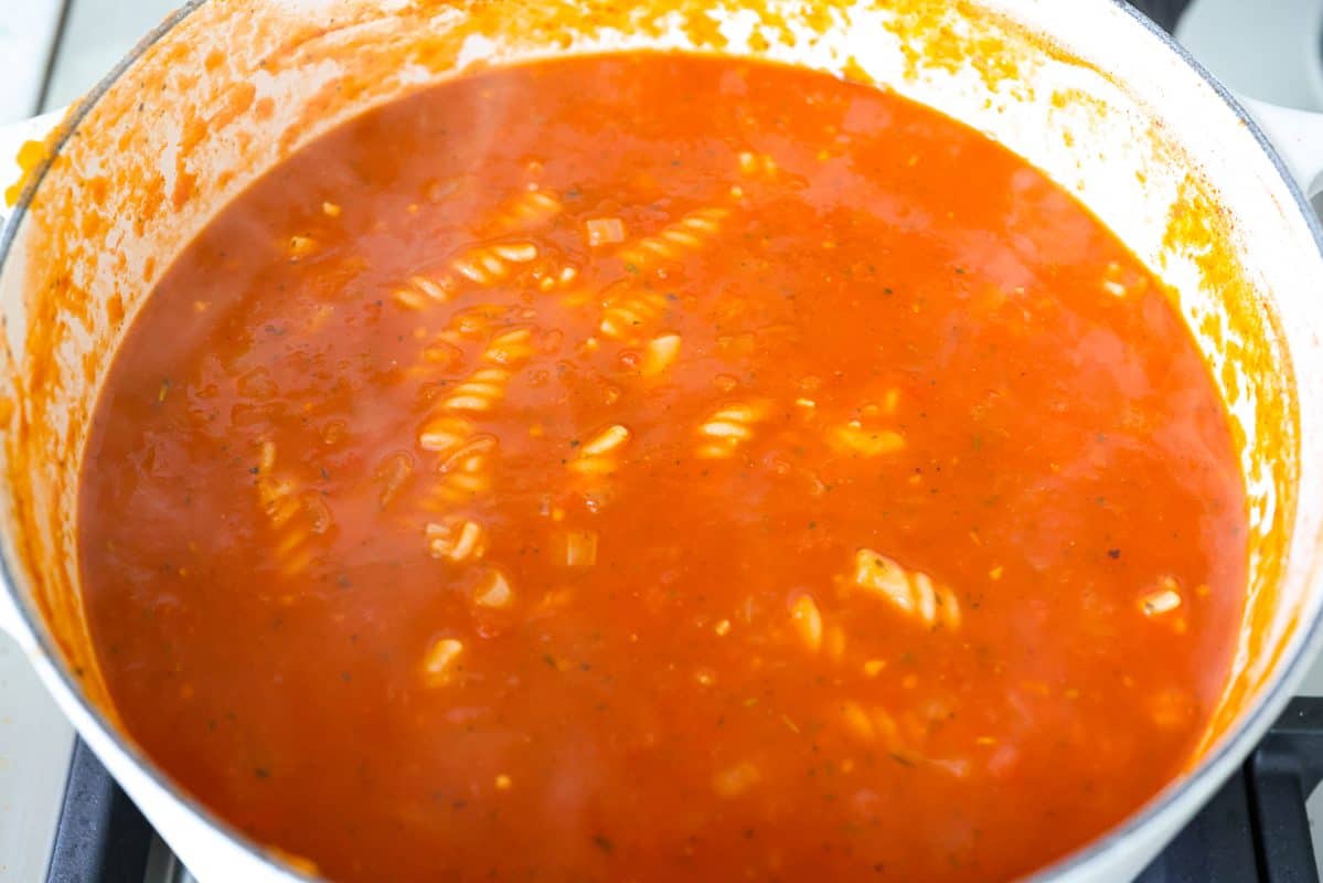 Craving chicken parm? Grab a spoon! This chicken parmesan soup is loaded with tender chicken, pasta, and a rich, creamy tomato broth. Finish with crispy, buttery breadcrumbs for a delicious twist on the Italian classic! Pasta added to the pot to cook.