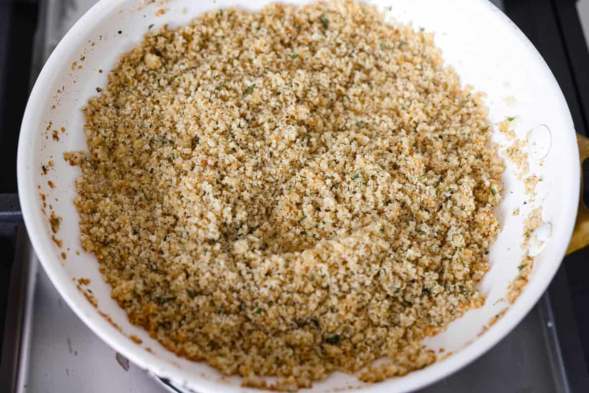 Craving chicken parm? Grab a spoon! This chicken parmesan soup is loaded with tender chicken, pasta, and a rich, creamy tomato broth. Finish with crispy, buttery breadcrumbs for a delicious twist on the Italian classic! Breadcrumbs added to the melted butter in the pan.