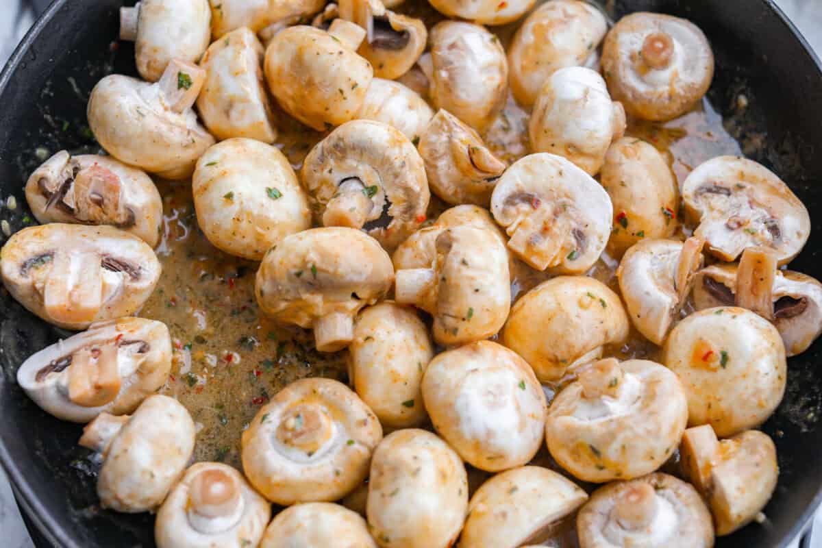 These Cowboy Mushrooms are so easy to make and packed with flavor! Tender, juicy mushrooms are coated in rich, garlicky cowboy butter. Just two ingredients and you've got a side dish that might steal the show! Button mushrooms added to the melted butter in the skillet.