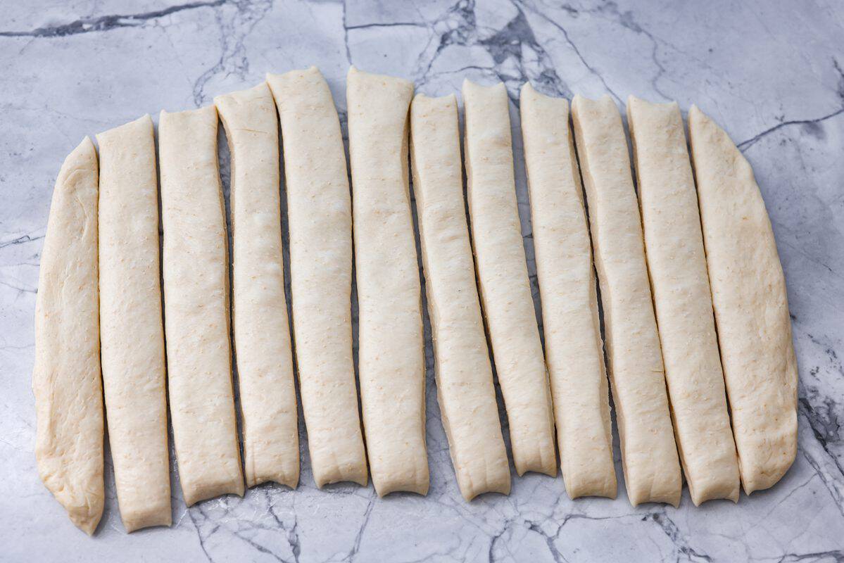 That buttery, garlicky Little Caesars Crazy Bread we all love? You can make it at home, and it's SO good! Soft, fluffy, and covered in Parmesan. Oh, and don't get me started on the garlic butter! Good luck eating just one! Dough shaped and spread out and sliced into breadstick shapes.