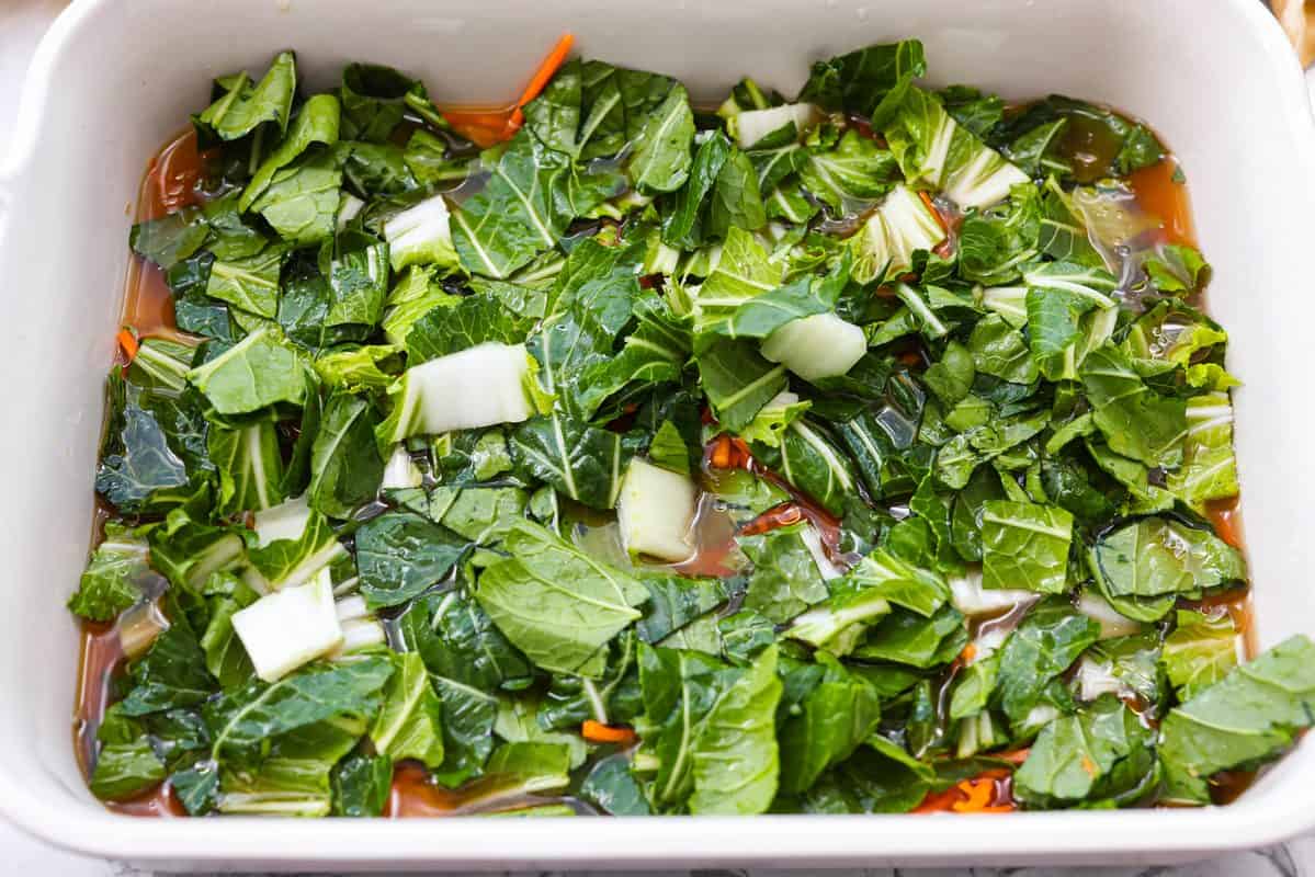 Crisp bok choy and shredded carrots added to the top of the rice and broth mixture. 