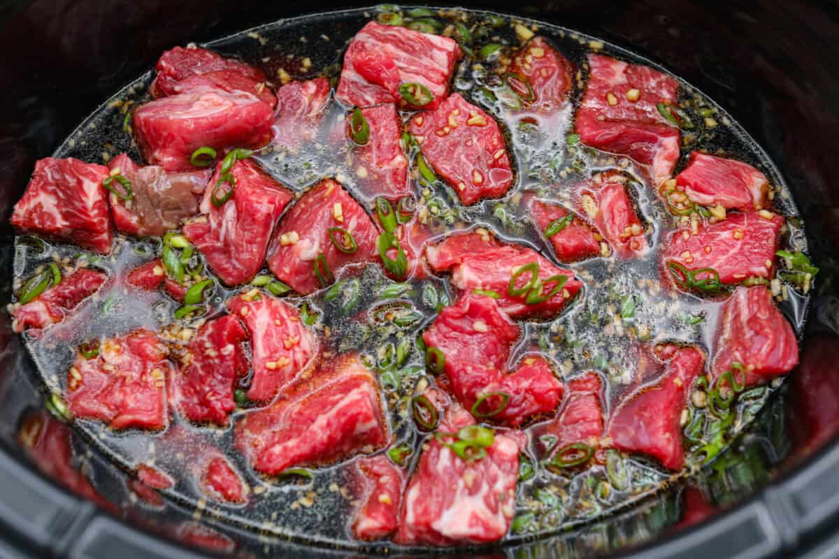 Sauce poured over the beef chunks in the slow cooker. 