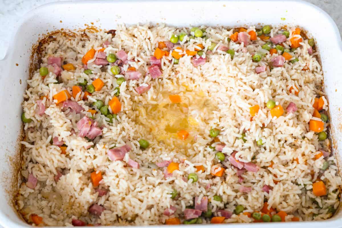 I LOVE fried rice, and my classic fried rice is already so easy, but I’m obsessed with this baked version! Dump everything into one baking dish, pop it in the oven, and dinner is served. It has all that savory fried rice flavor with less work! Eggs poured into the middle of the well made into the rice mixture.