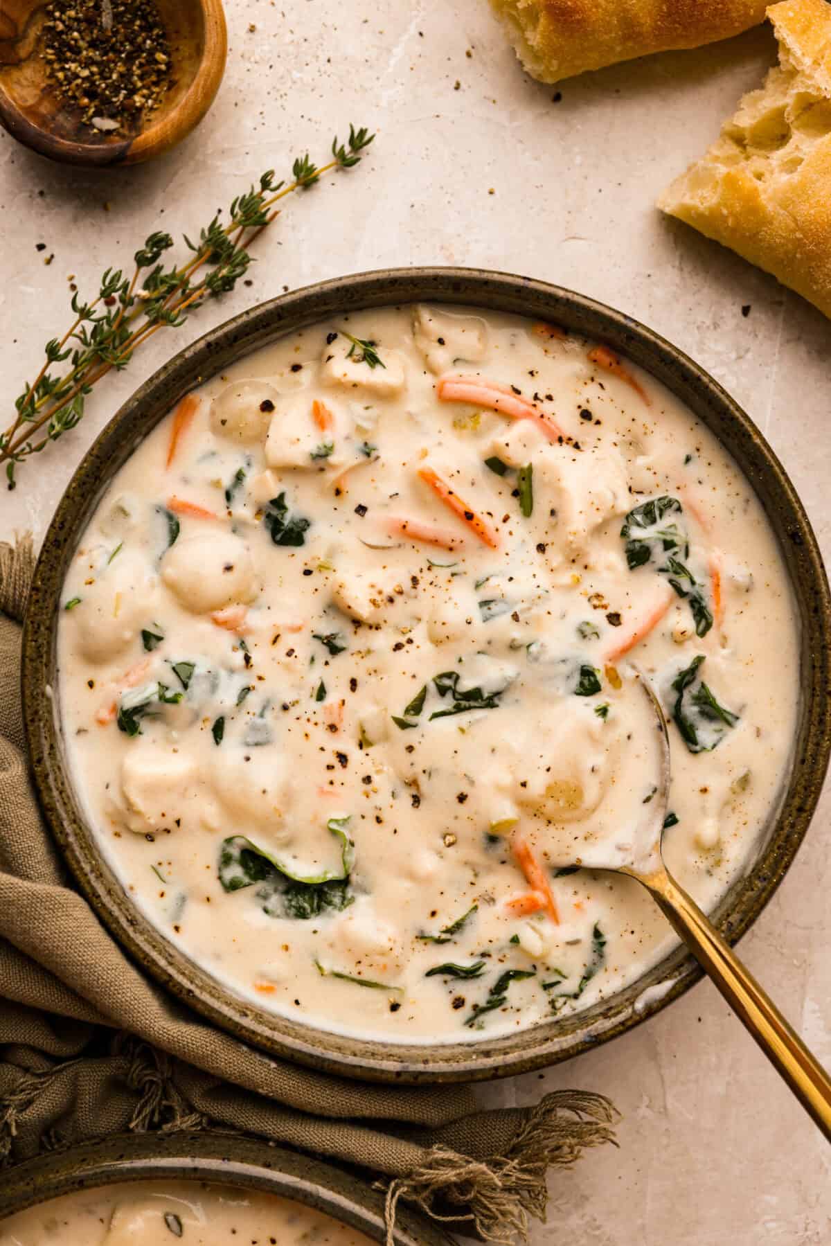 My creamy chicken gnocchi soup has everything I love about the Olive Garden favorite: tender chicken, pillowy gnocchi, fresh vegetables, and a rich, creamy broth. Even better, it comes together in just 30 minutes! Bowl of creamy chicken gnocchi soup (Olive Garden copycat) with a gold spoon.