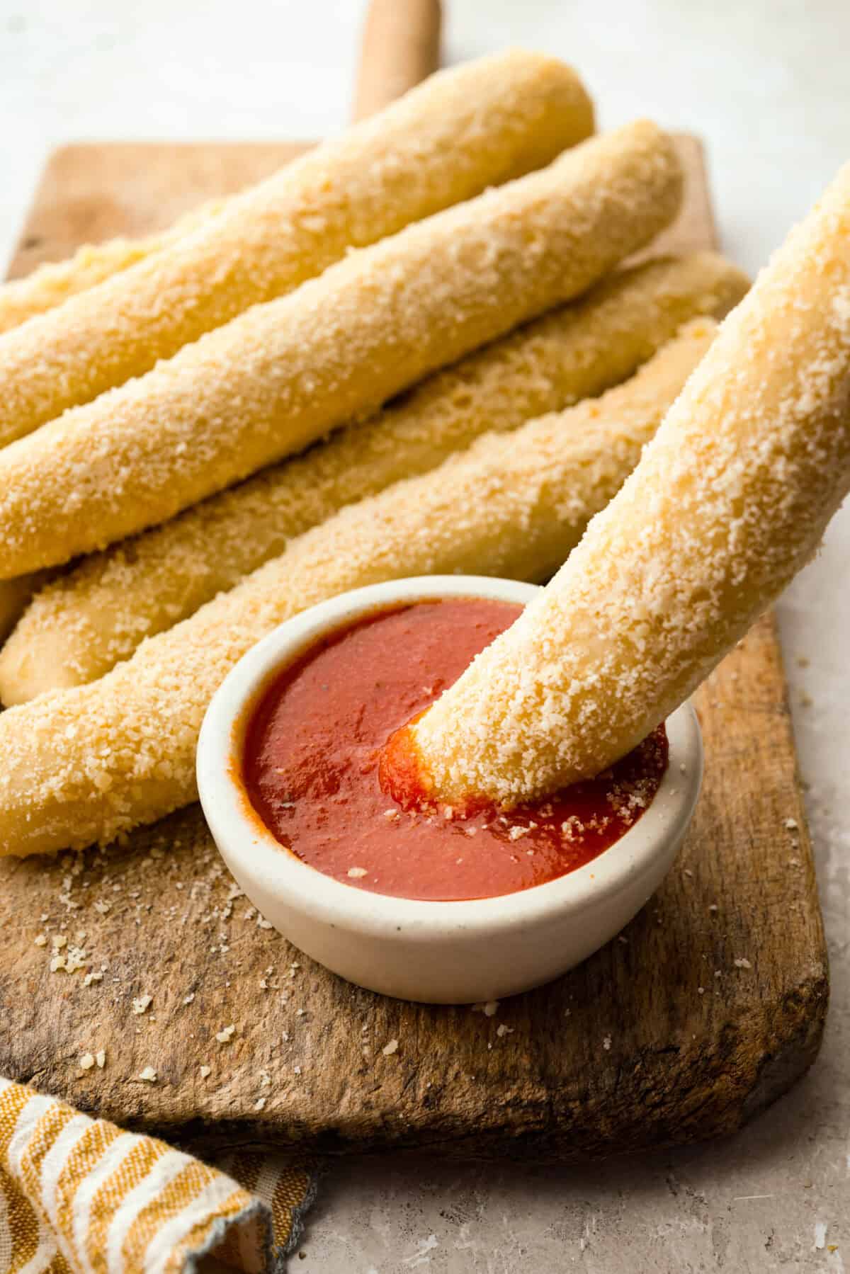 That buttery, garlicky Little Caesars Crazy Bread we all love? You can make it at home, and it's SO good! Soft, fluffy, and covered in Parmesan. Oh, and don't get me started on the garlic butter! Good luck eating just one! Soft garlic Parmesan Little Caesars crazy bread breadsticks served with marinara dipping sauce.