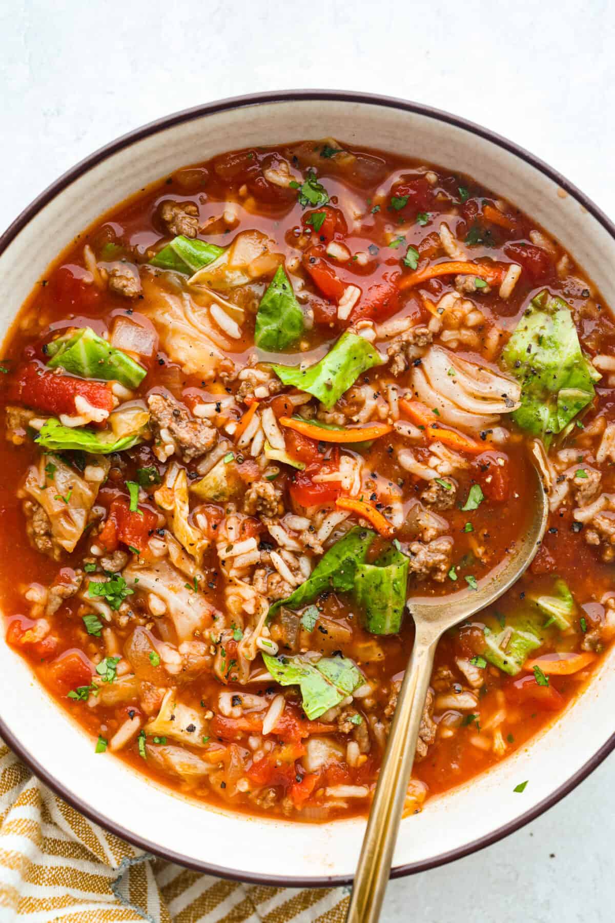 Serving bowl of crockpot cabbage roll soup garnished with some fresh cracked pepper.