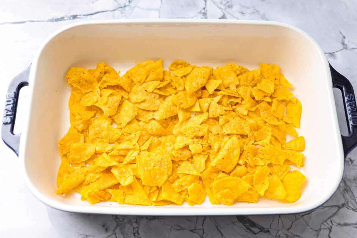 My taco casserole has everything you love about tacos baked into one cheesy, hearty dinner! It's loaded with seasoned ground beef, beans, corn, salsa, and tortilla chips. I love topping mine with sour cream, avocado, and fresh cilantro! Tortilla chips added to the bottom of the baking dish.